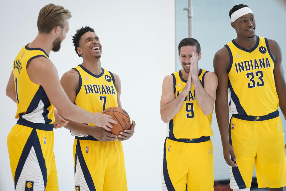 Indiana Pacers forward Domantas Sabonis, left, laughs with team mates Malcolm Brogdon (7), T.J. McConnell (9) and Myles Turner (33) while waiting for a photo shoot during the NBA basketball team's media day in Indianapolis, Monday, Sept. 27, 2021.(AP Photo/AJ Mast)