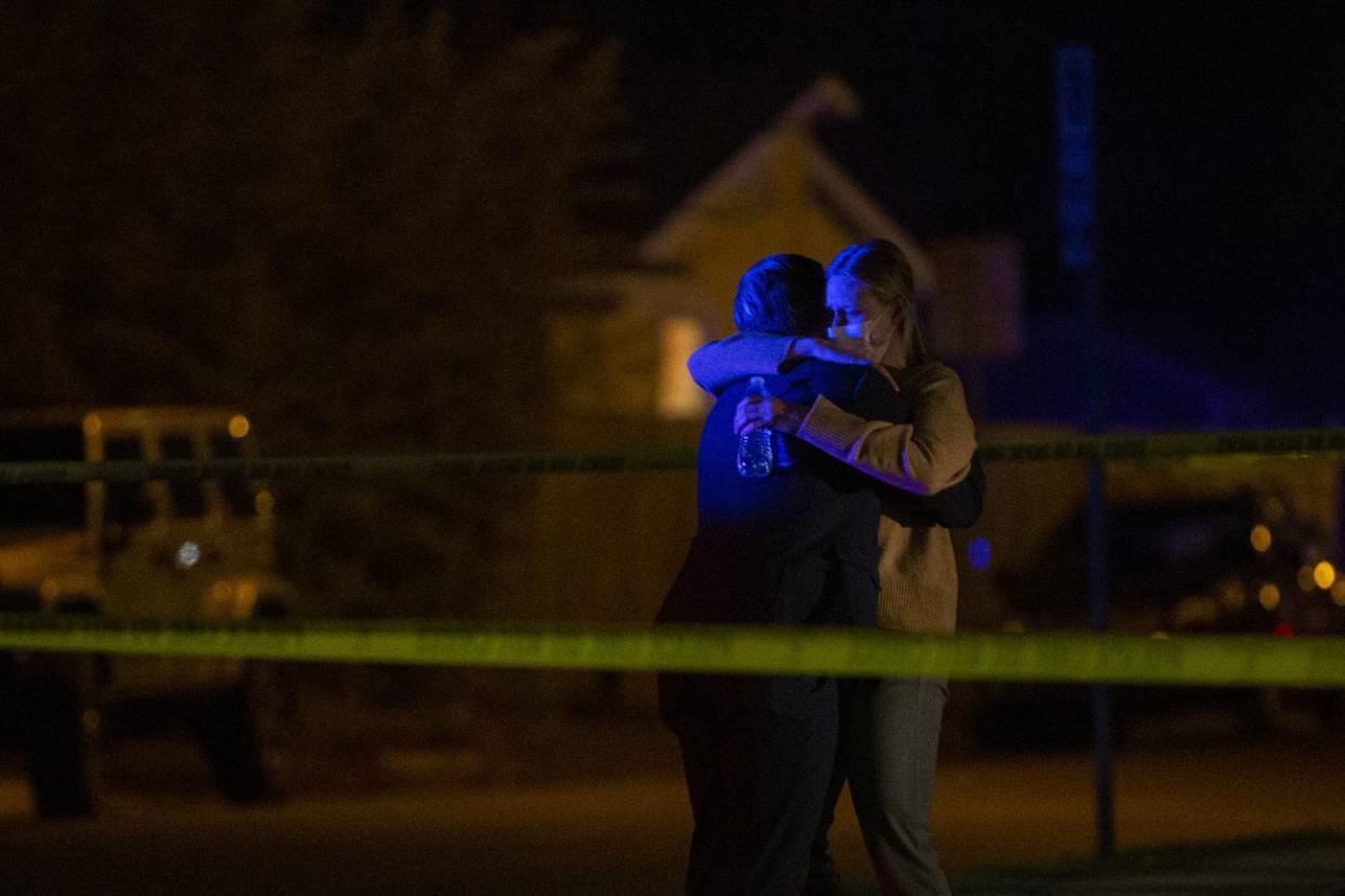A man and a woman embrace as Austin police officers and members of SWAT work the scene of a suspected hostage situation at a doctor's office in Austin, Texas.
