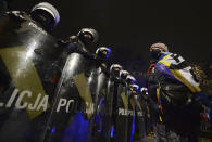 Riot police line up as a crowd gathers outside the house of Poland's ruling conservative party leader Jaroslaw Kaczynski in Warsaw, Poland, Friday, Oct. 23, 2020. Protesters vented anger for a second day across Poland over a court ruling that declared abortions of fetuses with congenital defects unconstitutional. The hundreds of protesters who gathered in many cities defied a COVID-19-related ban on gatherings that was imposed nationwide on Friday. (AP Photo/Czarek Sokolowski)