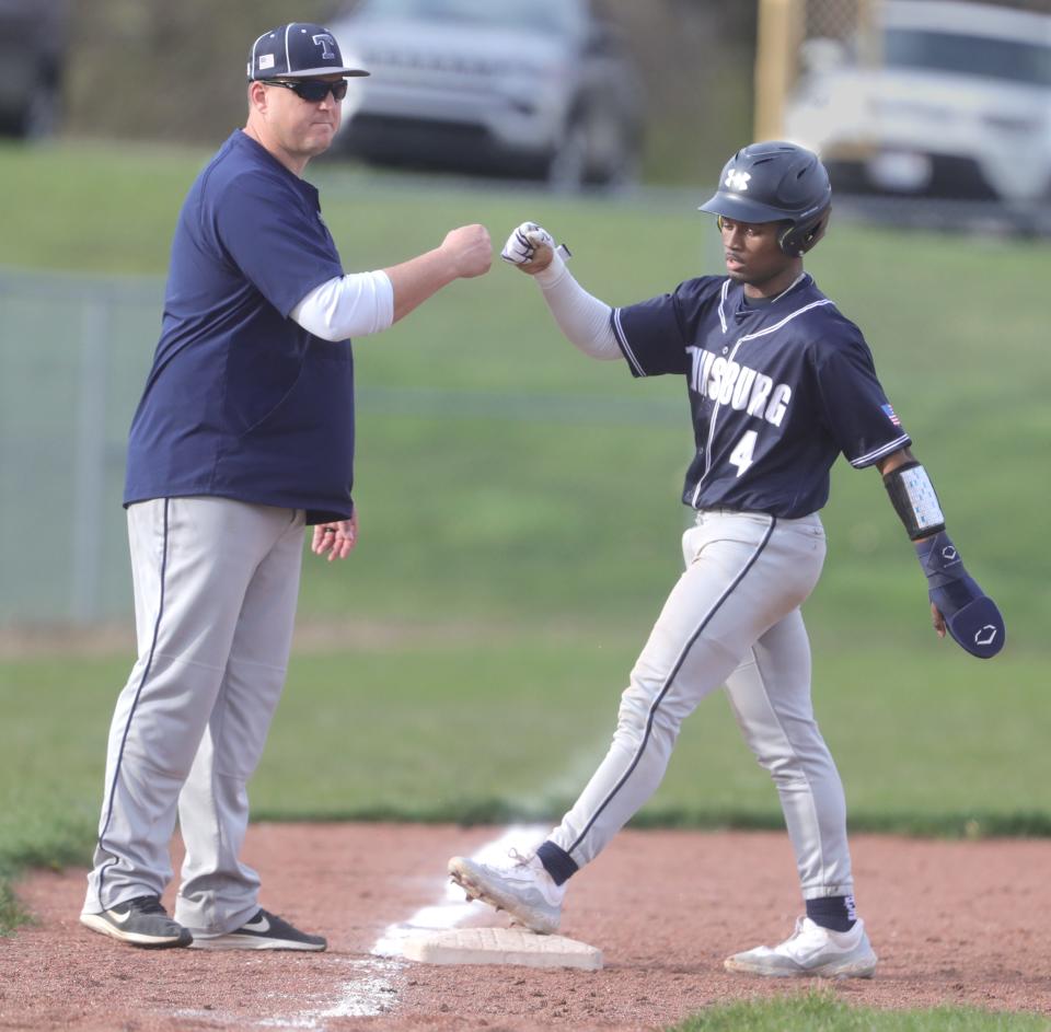 Twinsburg baseball coach Jim Lipinski fist bumps Jaden Dye after he reached third base during a game against Brecksville on Tuesday, April 9, 2024 in Brecksville.