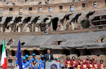 Italy's Prime Minister Matteo Renzi (C) speaks during a news conference about the latest stage of restoration of the Colosseum by luxury goods firm Tod's in Rome, Italy, July 1, 2016. REUTERS/Alessandro Bianchi