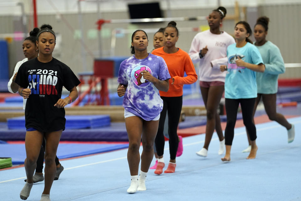 FILE - In this May 11, 2021, file photo, gymnast Jordan Chiles, center, trains in Spring, Texas. The 20-year-old Chiles will compete at the U.S. Championships this weekend hoping to build off a strong performance at the U.S. Classic, where she finished second to Olympic and world champion Simone Biles. (AP Photo/David J. Phillip, File)