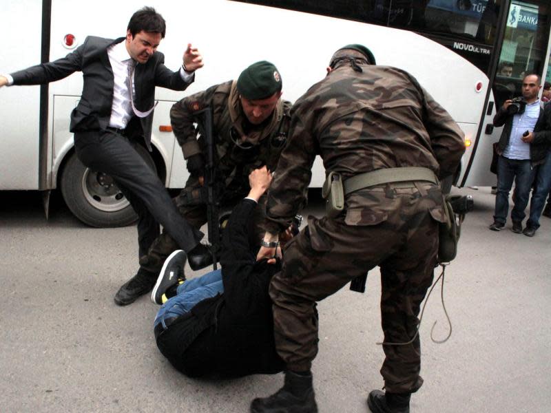 Erdogan-Berater Yusuf Yerkel (l.) tritt einen Demonstranten zusammen, der von zwei Polizisten festgehalten wird. Foto: Depo Photos