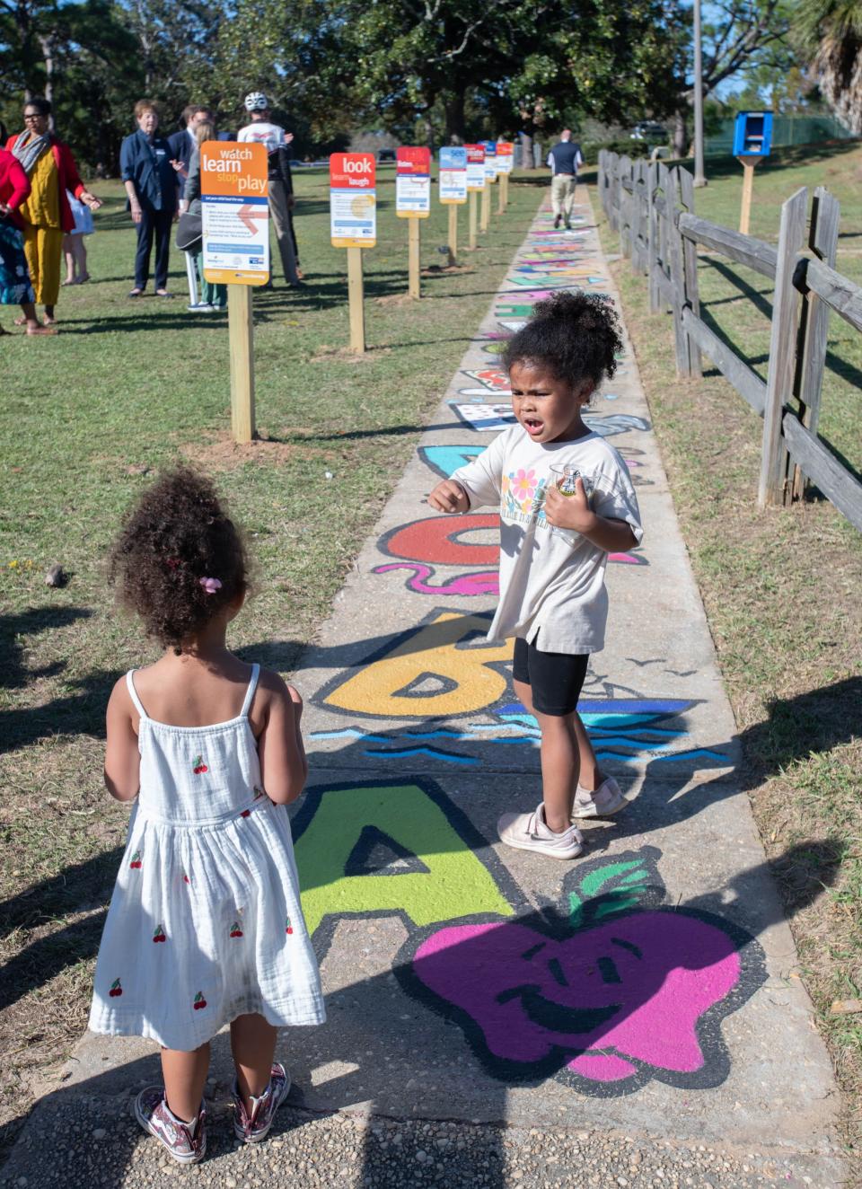 Georgia Smith, 4, right, goes over her ABC's as she walks with her sister Indie, 2, along the new Born Learning Trail at Bayview Park in Pensacola on Tuesday, Oct. 24, 2023. This newest Born Learning Trail was created by the Pensacola News Journal in association with Ready Kids!, the United Way of West Florida, and the Sunstone Project.
