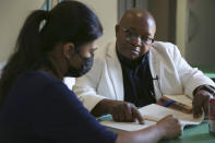 Parishioner and translator Berenice Velazquez, left, helps the Rev. Athanasius Abanulo with his Spanish before the afternoon Mass at Immaculate Conception Catholic Church in Wedowee, Ala., on Sunday, Dec. 12, 2021. After moving to the Southern U.S. one year ago, Abanulo began learning Spanish to better connect with his largely Hispanic congregations. (AP Photo/Jessie Wardarski)