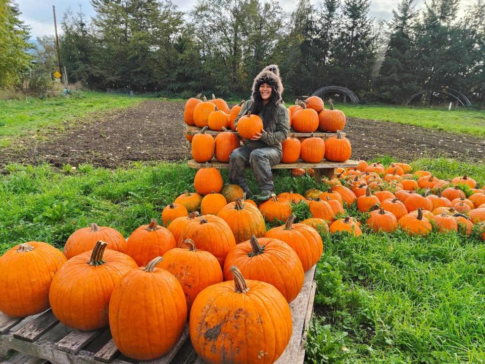 Savannah Flynn sits among her pumpkin crop harvested on her farm in Everson, Wash.