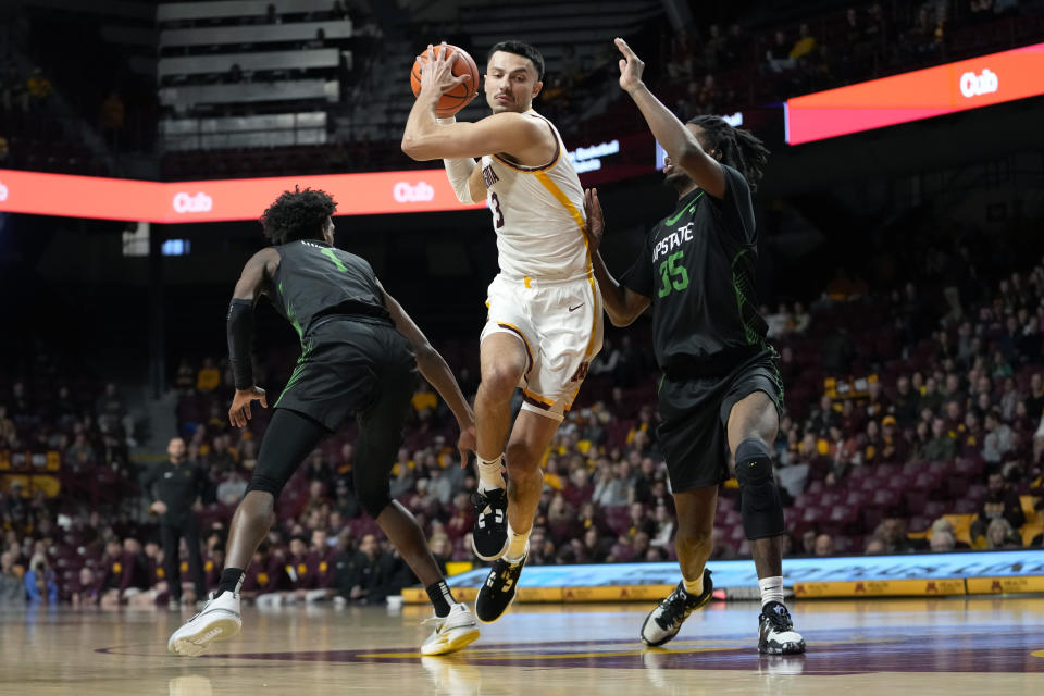 Minnesota forward Dawson Garcia works toward the basket as USC Upstate guard Nick Alvesl, left, and forward Ahmir Langlais, right, defend during the first half of an NCAA college basketball game, Saturday, Nov. 18, 2023, in Minneapolis. (AP Photo/Abbie Parr)