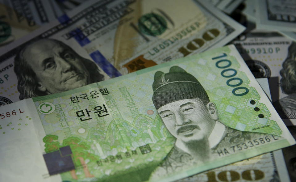 South Korean 10,000 won note is seen on U.S. 100 dollar notes in this picture illustration taken in Seoul, South Korea, December 15, 2015. As investors brace for this week's historic U.S. interest rate decision, central banks in Asia's emerging markets will be standing by a quarter of a trillion dollars in emergency liquidity lines with China and Japan to prevent routs in their currencies.   REUTERS/Kim Hong-Ji