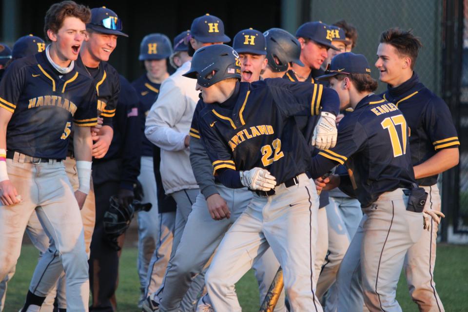 Hartland's Ty Kraut (22) is met at home plate by his teammates after hitting a two-run homer in an 8-2 victory over Howell on Wednesday, May 3, 2023.