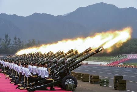 Paramilitary policemen and members of a gun salute team fire cannons during a training session for a military parade to mark the 70th anniversary of the end of the World War Two, at a military base in Beijing, China, August 1, 2015. REUTERS/Stringer