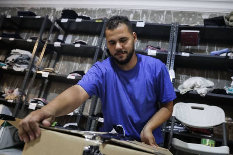 A volunteer seals a donations box at the Pali Boutique. Pali Boutique, founded by the voluntary group Network for Palestine, is a storage area providing essential clothing, household goods, toys, hygiene products and more to Palestinian families who fled the Gaza war to Cairo. Gehd Hamdy/dpa