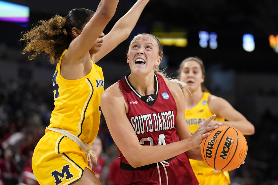 South Dakota's Hannah Sjerven, right, heads to the basket as Michigan's Cameron Williams defends during the first half of a college basketball game in the Sweet 16 round of the NCAA women's tournament Saturday, March 26, 2022, in Wichita, Kan. (AP Photo/Jeff Roberson)