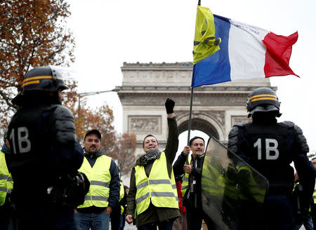 Protesters wearing yellow vests, a symbol of a French drivers' shout out slogans during protest against higher fuel prices, block the street in Paris, France, November 24, 2018. REUTERS/Benoit Tessier