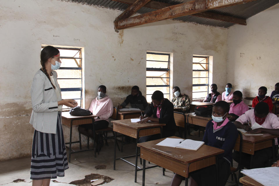 Cameron Beach, teaches children in Dedza, near Lilongwe, Malawi, Friday, July 23, 2021. Beach, a former Peace Corps volunteer, is living in rural Malawi teaching English at a rural high school where she had been sent by the United States government 18-months before COVID-19 began sweeping the world. (AP Photo/Roy Nkosi)