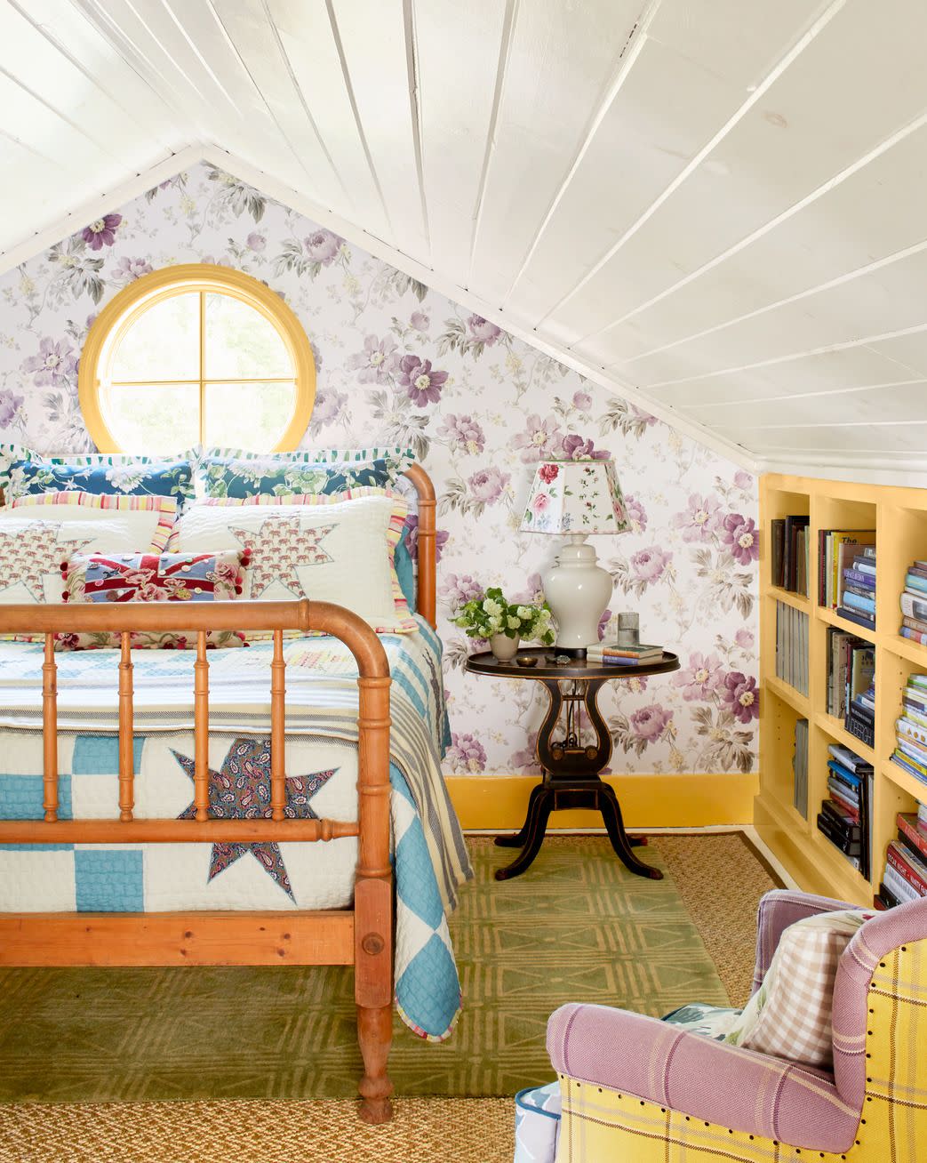 attic bedroom with white shiplap ceiling, purple floral wallpaper, and patterned bedding