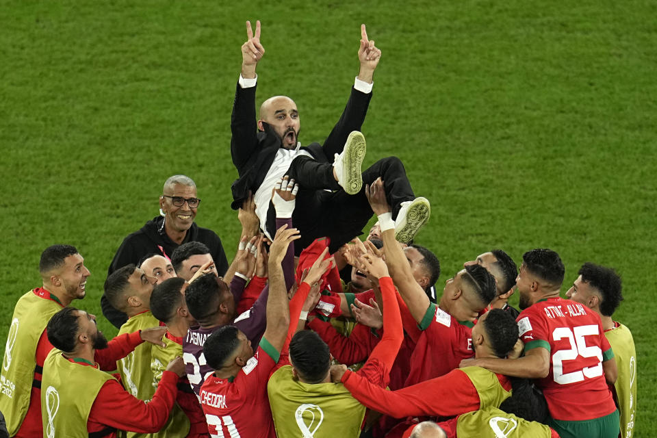 Morocco's head coach Walid Regragui is thrown in the air at the end of the World Cup round of 16 soccer match between Morocco and Spain, at the Education City Stadium in Al Rayyan, Qatar, Tuesday, Dec. 6, 2022. (AP Photo/Abbie Parr)