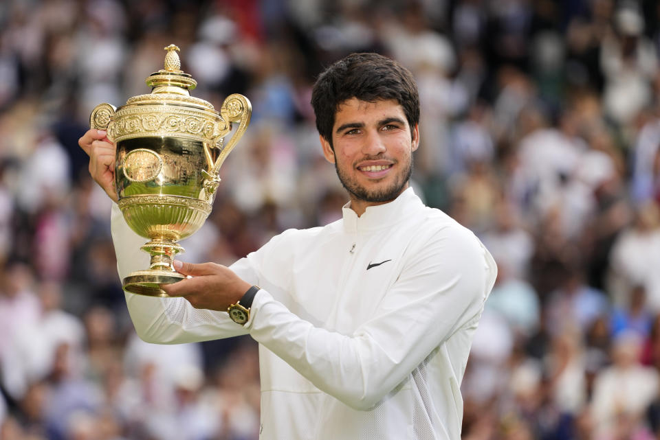 FILE - Spain's Carlos Alcaraz celebrates with the trophy after beating Serbia's Novak Djokovic to win the final of the men's singles on day fourteen of the Wimbledon tennis championships in London, Sunday, July 16, 2023. This year's Wimbledon tournament begins on Monday, July 1.(AP Photo/Kirsty Wigglesworth, File