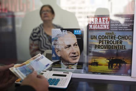 A member of the French community in Israel holds Euros at a currency exchange booth in Netanya, a city of 180,000 on the Mediterranean north of Tel Aviv, that has become the semi-official capital of the French community in Israel January 20, 2015. REUTERS/Amir Cohen