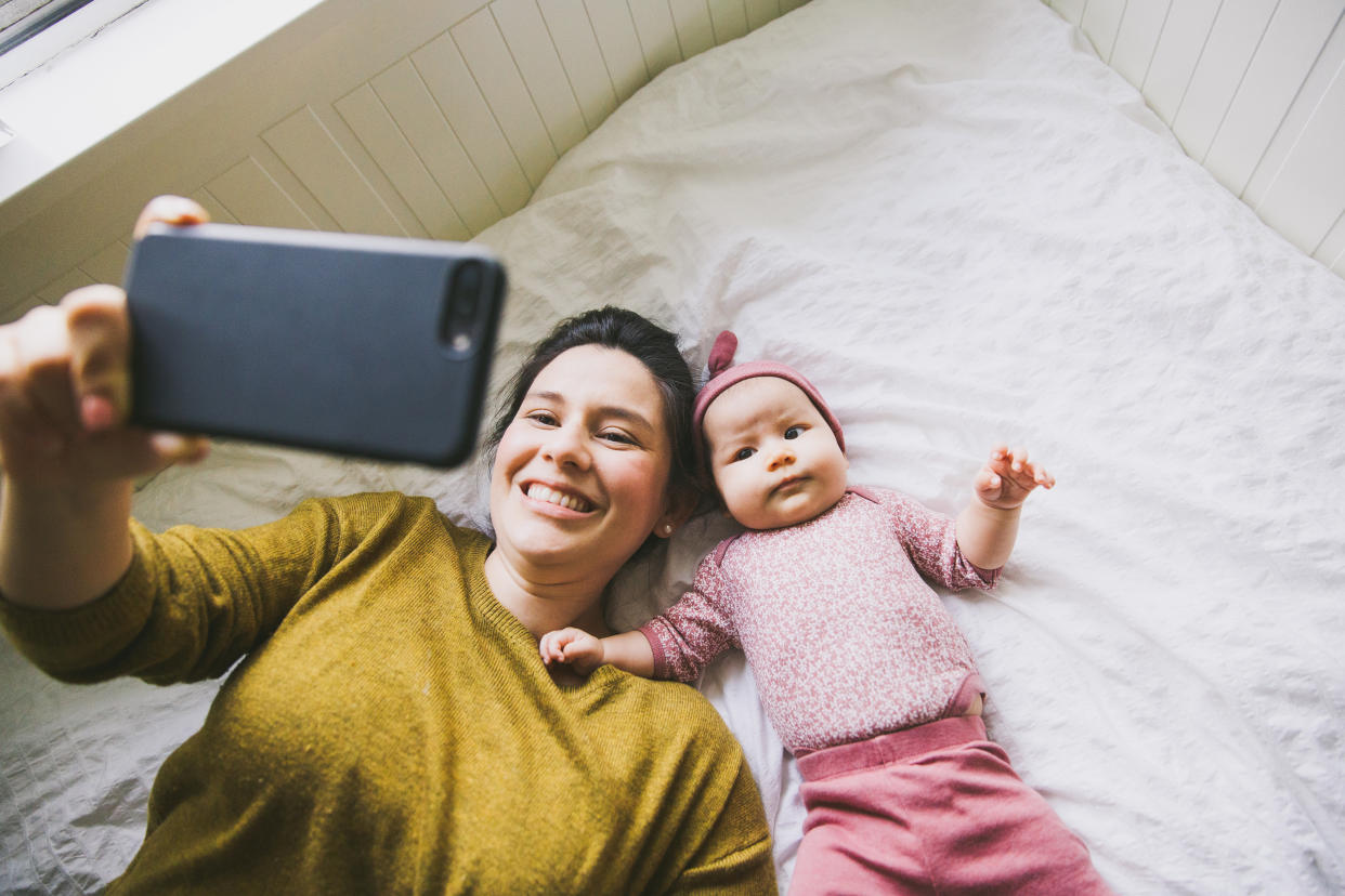 Perfect parents pressure: Mother taking pictures with baby for social media. (Getty Images)