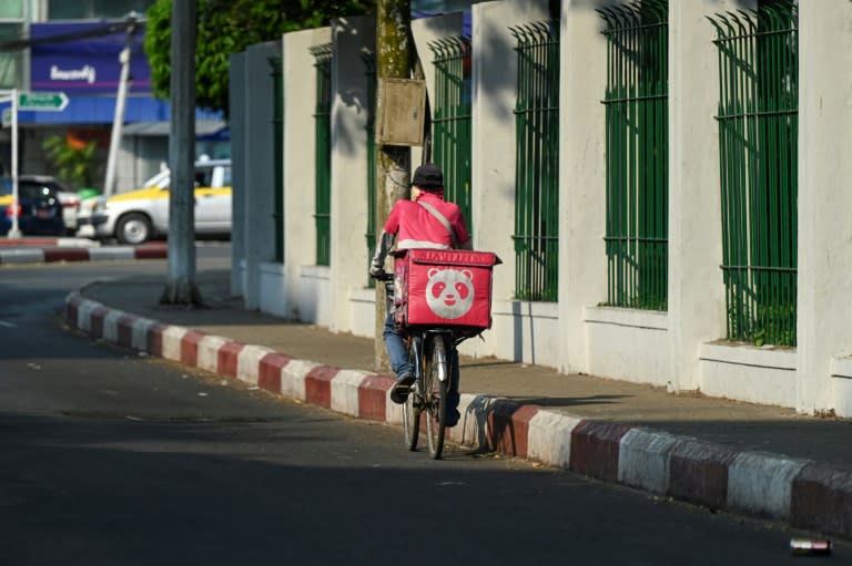 Un livreur à vélo dans une rue de Rangoun, pendant une vague de chaleur en Birmanie, le 29 avril 2024 (Sai Aung MAIN)