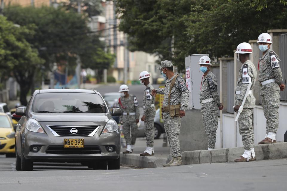 Soldiers stand guard outside the military hospital where Defense Minister Carlos Holmes Trujillo died from complications of COVID-19 in Bogota, Colombia, Tuesday, Jan. 26, 2021. President Ivan Duque said that Trujillo died early Tuesday. (AP Photo/Fernando Vergara)