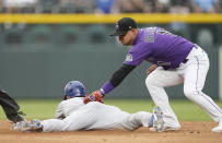 Colorado Rockies shortstop Jose Iglesias, right, tags out Los Angeles Dodgers' Gavin Lux who was trying to advance from first to second base on a fly ball hit by Trayce Thompson during the third inning of a baseball game Monday, June 27, 2022, in Denver. (AP Photo/David Zalubowski)