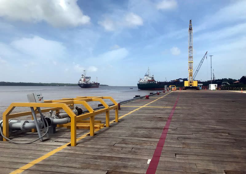 FILE PHOTO: Vessels carrying supplies for an offshore oil platform operated by Exxon Mobil are seen at the Guyana Shore Base Inc wharf on the Demerara River south of Georgetown