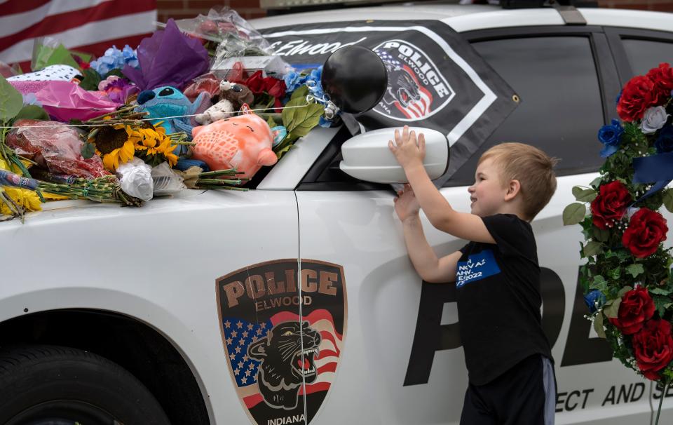 Houston McPhearson looks at a memorial for Elwood Police Officer Noah Shahnavaz, Monday, Aug. 1, 2022 in Elwood, Ind. Officer Shahnavaz was killed early Sunday morning, July 31, 2022, during a traffic stop in Madison County. 