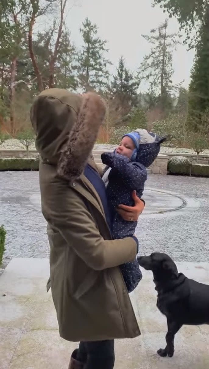 <p>Meghan holds a bundled-up Archie outside as it snows, in this still from a video that was likely taken during December 2019.</p>
