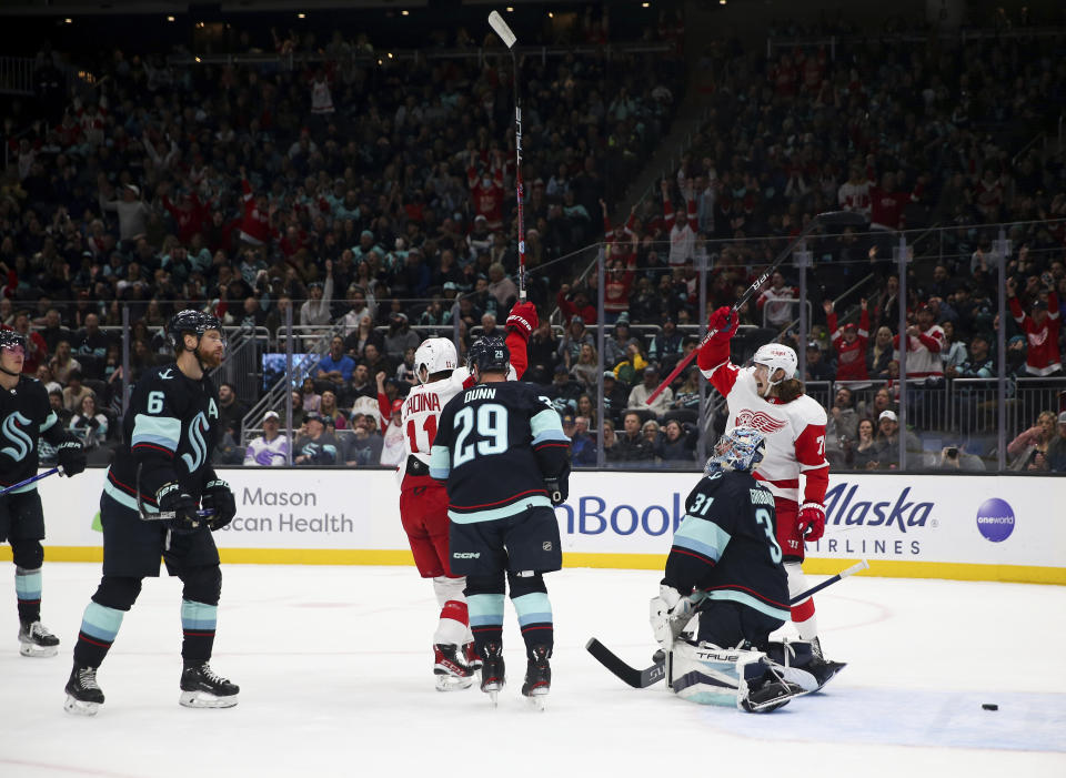 Detroit Red Wings right wing Filip Zadina (11) and Oskar Sundqvist (70) celebrate a goal by center Pius Suter (24) against the Seattle Kraken during the first period of an NHL hockey game Saturday, Feb. 18, 2023, in Seattle. (AP Photo/ Lindsey Wasson)