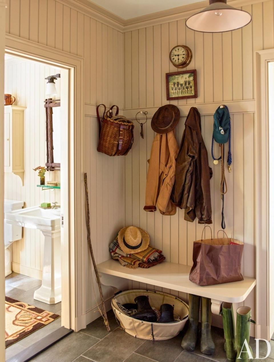 This beadboard-paneled mudroom has a peg rail and basket storage.