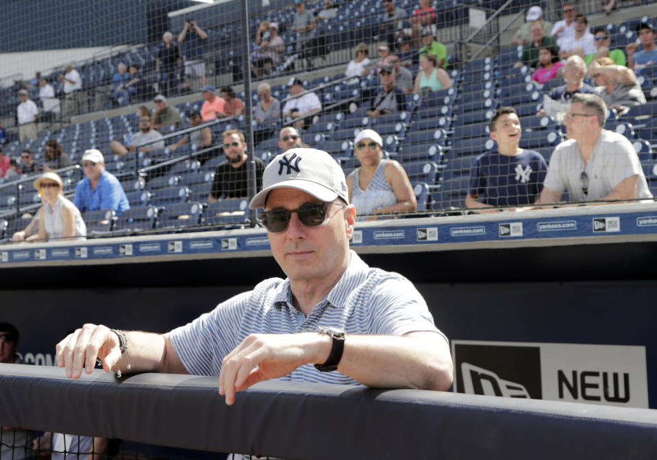 New York Yankees General Manager Brian Cashman looks out from the dugout at baseball spring training camp, Wednesday, Feb. 21, 2018, in Tampa, Fla. (AP Photo/Lynne Sladky)