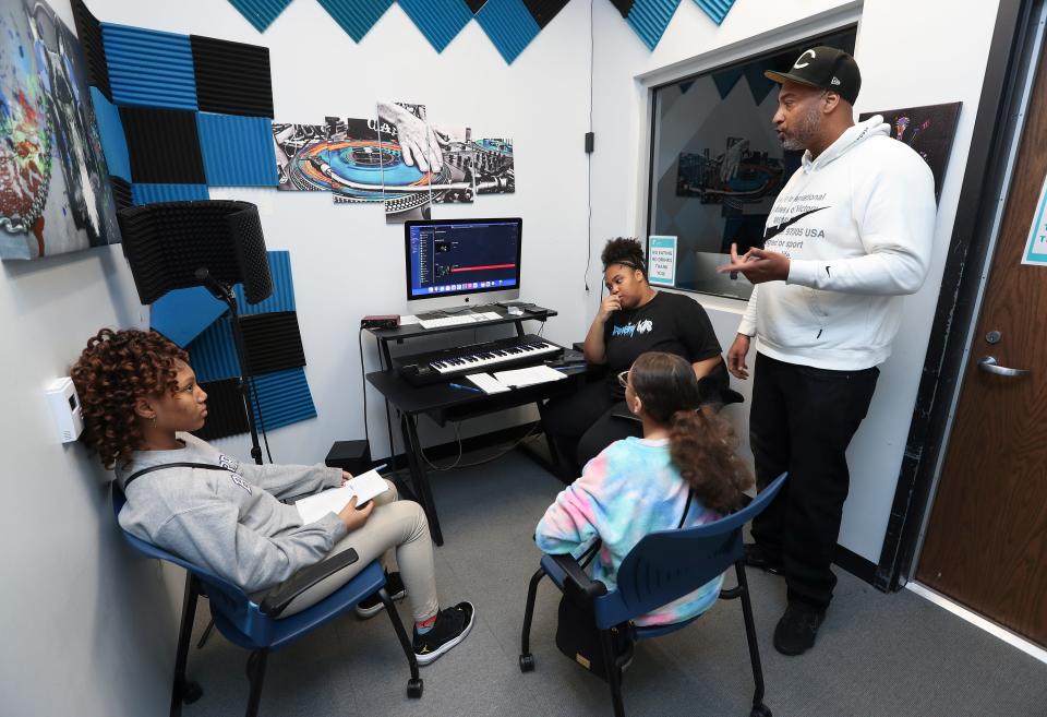 Lavon Clack, right, CEO of Prominent Youth of America at the YMCA on west Broadway, offers advice to Lyric Knox, 13, left, Canaan Vaught, 12, and his daughter Ciniya Clack, 18, wearing black t-shirt, as they compose lyrics to a song they were working on in Louisville, Ky. on Mar. 15, 2023.  The program is designed to promote creativity and introduce business skills to JCPS students.