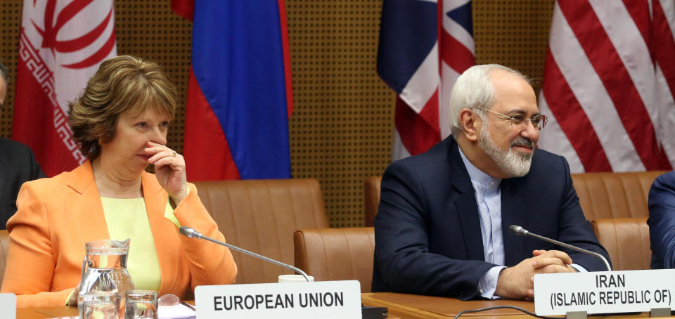 European foreign policy chief Catherine Ashton, left, and Iranian Foreign Minister Mohamad Javad Zarif, right, wait for the start of closed-door nuclear talks in Vienna, Austria, Wednesday, March 19, 2014. Iran and six world powers appear to be tackling less sensitive issues first at nuclear talks meant to curb Tehran's atomic activities in exchange for full sanctions relief. Iran's official IRNA news agency says Wednesday's talks are focusing on a heavy water reactor. The six want the nearly finished reactor shut down, or converted to a type that produces less plutonium, a material that could be used to make nuclear weapons. (AP Photo/Ronald Zak)