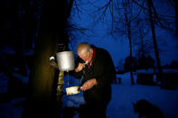 Yuri Baikov, 69, brushes his teeth at his small farm situated in a forest near the village of Yukhovichi, Belarus, February 8, 2018. REUTERS/Vasily Fedosenko