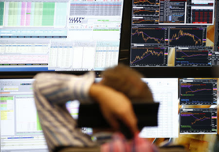 FILE PHOTO - A trader sits in front of the computer screens at his desk at the Frankfurt stock exchange, Germany, June 29, 2015. REUTERS/Ralph Orlowski