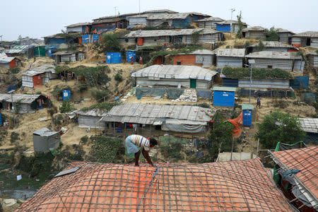 FILE PHOTO: A Rohingya refugee repairs the roof of his shelter at the Balukhali refugee camp in Cox's Bazar, Bangladesh, March 5, 2019. REUTERS/Mohammad Ponir Hossain/File Photo