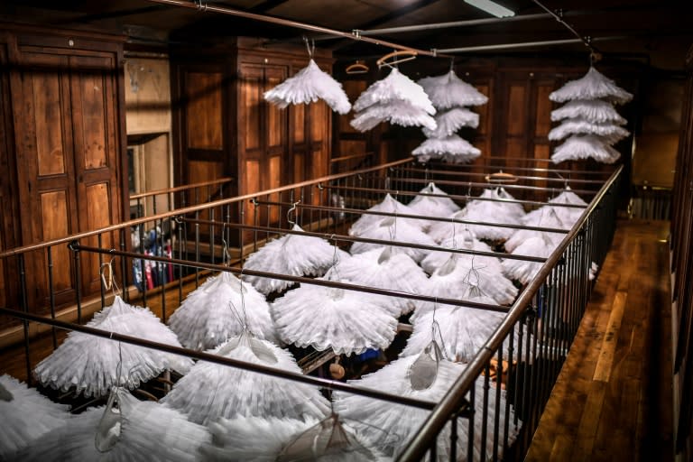 Dozens of white tutus hanging in a historic room known as "central" at the Paris Opera