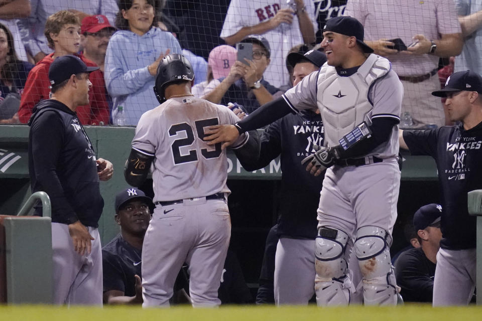 New York Yankees' Gleyber Torres (25) is congratulated by teammates after scoring on a throwing error by Boston Red Sox catcher Connor Wong, after driving in Aaron Judge and Aaron Hicks on a single, during the fifth inning of a baseball game at Fenway Park, Wednesday, Sept. 14, 2022, in Boston. (AP Photo/Charles Krupa)