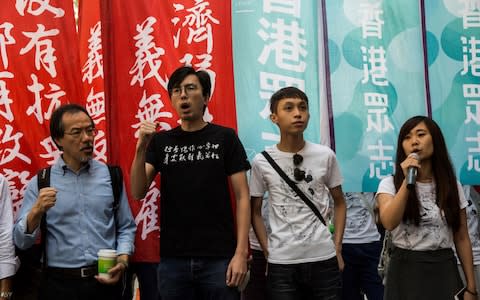 Pro-democracy activists Avery Ng (centre L), Figo Chan (centre R) and Tiffany Yuen (R) shout slogans outside the Court of Final Appeal  - Credit: AFP