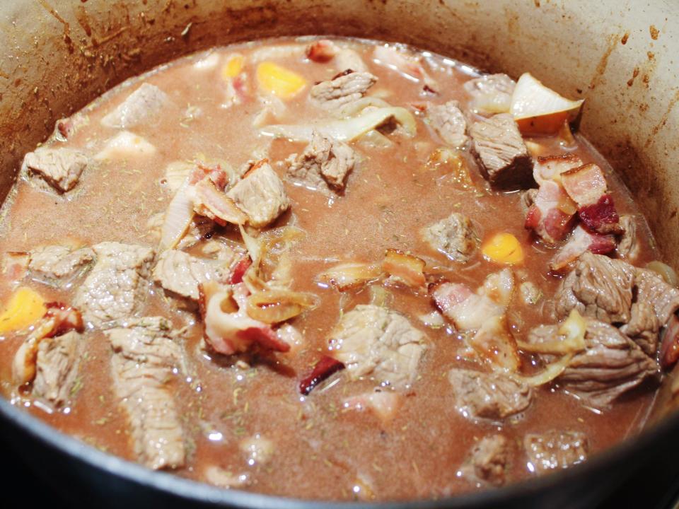 beef bacon stock wine onions and carrots in the dutch oven