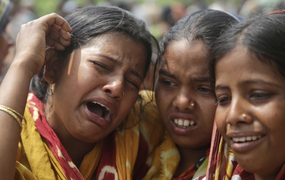 Relatives of victims killed in ethnic violence mourn at a burial ground at Narayanguri village, in the northeastern Indian state of Assam, Saturday, May 3 2014. Police in India arrested 22 people after separatist rebels went on a rampage, burning homes and killing dozens of Muslims in the worst outbreak of ethnic violence in the remote northeastern region in two years, officials said Saturday. (AP Photo/Anupam Nath)