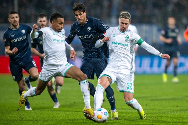 Bremen's Felix Agu (L) and Marco Friedl (R) battle for the ball with Bochum's Goncalo Paciencia during the German Bundesliga soccer match between VfL Bochum and Werder Bremen at Vonovia Ruhrstadion. David Inderlied/dpa