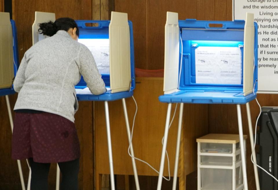 A voter fills out a paper ballot in Providence during the statewide primary election in 2018.