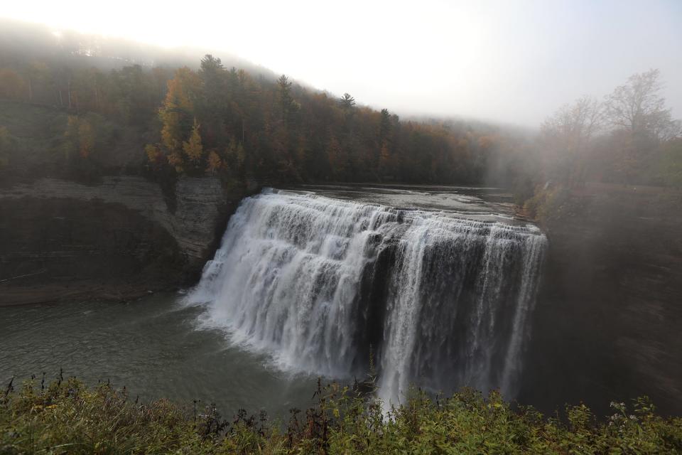 Fall colors peek through the fog at Middle Falls at Letchworth State Park..