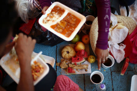 Central American migrants, moving in a caravan through Mexico toward the U.S. border, eat at a shelter set up for them by the Catholic church, in Puebla, Mexico April 6, 2018. REUTERS/Edgard Garrido