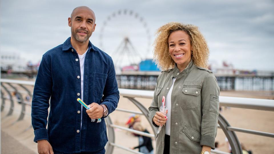 all about britain, alex beresford and rita hebden at the seaside holding sticks of rock