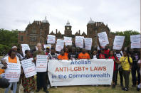 Campaigner Peter Tatchell, third from left, and demonstrators hold up signs and a banner during an LGBTQ+ protest at Aston Hall ahead of the Commonwealth Games in Birmingham, England, Thursday July 28, 2022. (Peter Byrne//PA via AP)