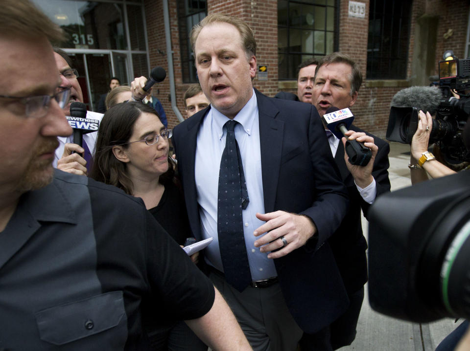 Former Boston Red Sox pitcher Curt Schilling, center, is followed by members of the media as he departs the Rhode Island Economic Development Corporation headquarters, in Providence, R.I., Wednesday, May 16, 2012. Schilling briefed Rhode Island Gov. Lincoln Chafee and economic development officials Wednesday during a closed-door meeting that could determine the fate of his video game company. (AP Photo/Steven Senne)