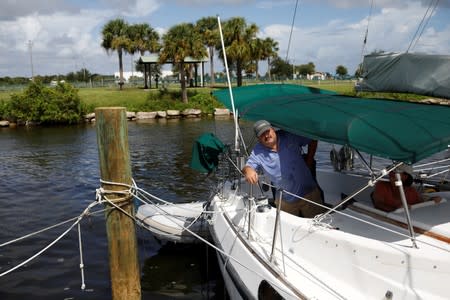 Ned Keahey, who lives in a sailboat with his wife Lisa and plans to stay aboard during Hurricane Dorian, secures his sailboat at a marina in Titusville